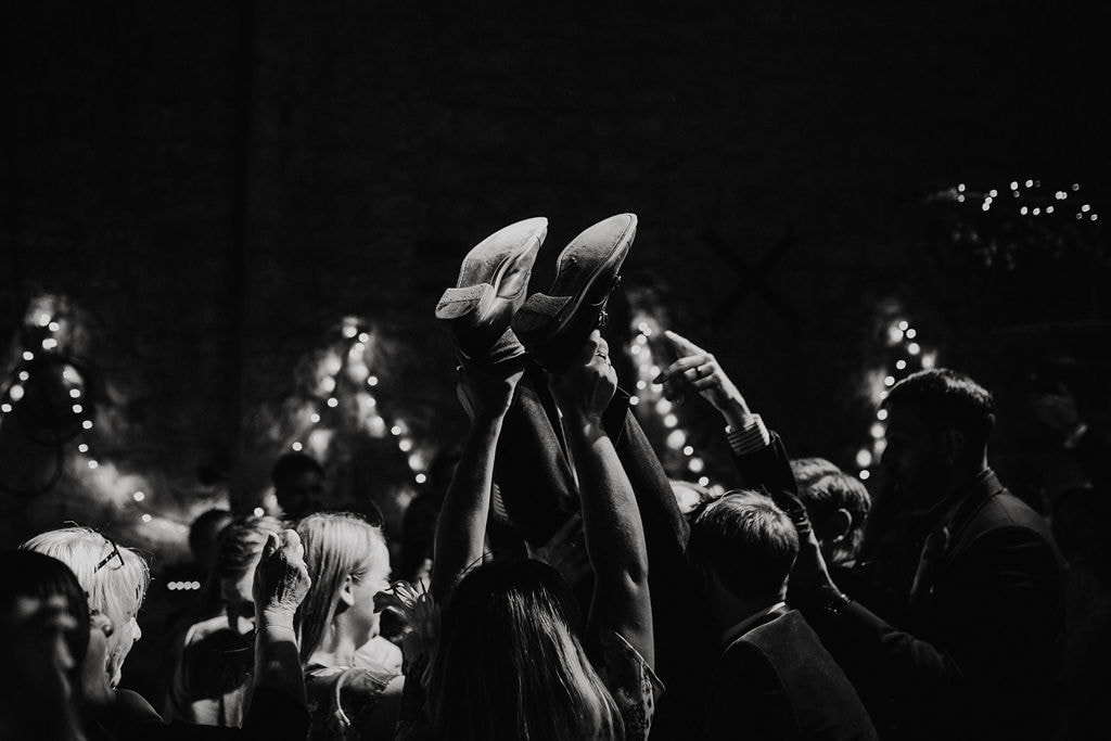 Groom being thrown in the air on a dance floor at wedding 
